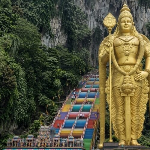 Batu Caves Kuala Lumpur with golden Lord Murugan statue and colourful staircase