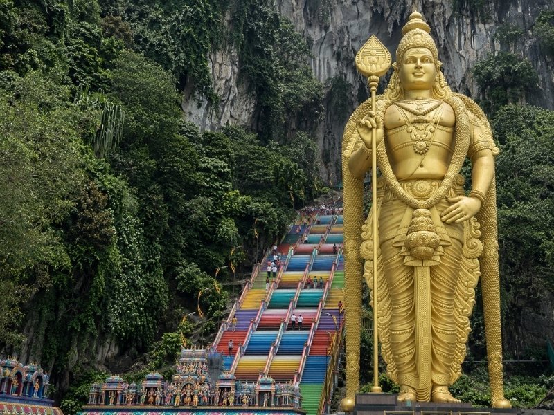 Batu Caves Kuala Lumpur with golden Lord Murugan statue and colourful staircase