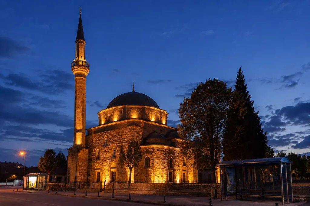 Historic Ottoman mosque illuminated against the evening sky in Antalya, Turkey.