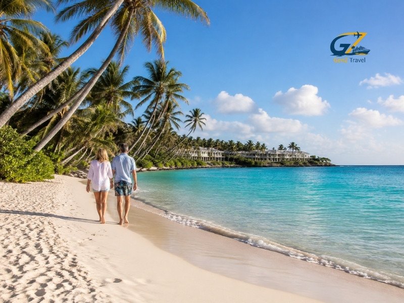 Couple enjoying a holiday in the Caribbean while walking along a tropical palm-fringed beach near a luxury resort.