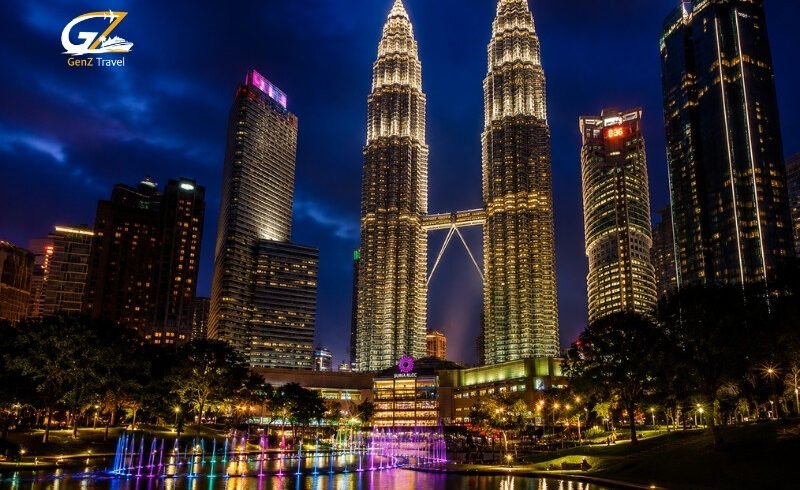 Kuala Lumpur skyline at night with illuminated Petronas Twin Towers and fountain reflections