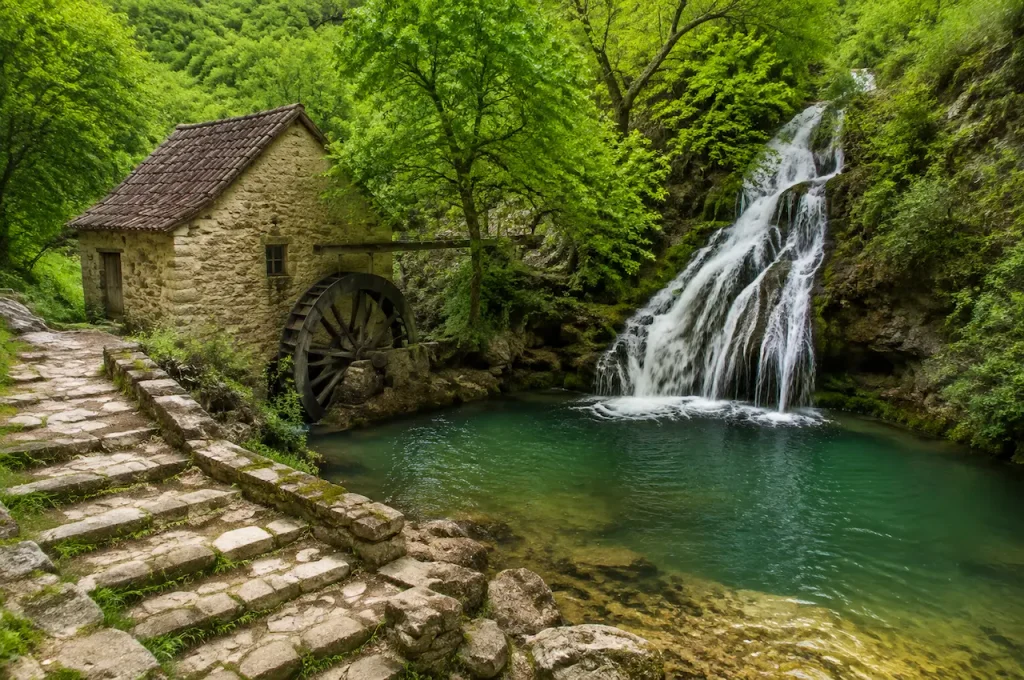 Historic watermill beside a forest waterfall and turquoise pool near Antalya.