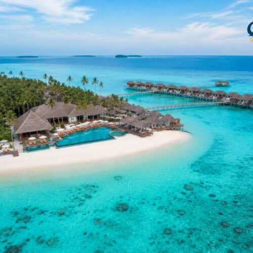 Aerial view of Centara Ras Fushi Resort & Spa Maldives with overwater villas, turquoise lagoon and white sandy beach