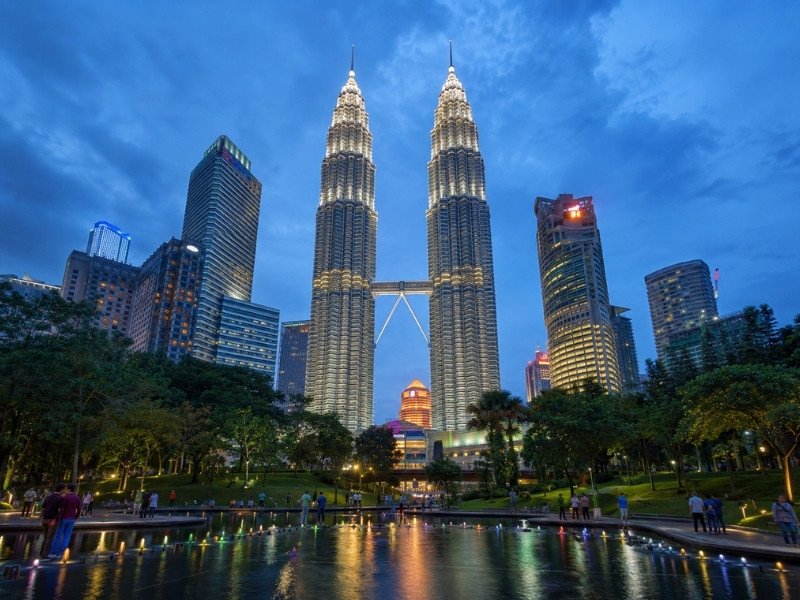 Petronas Twin Towers Kuala Lumpur illuminated at night with city lights and reflections