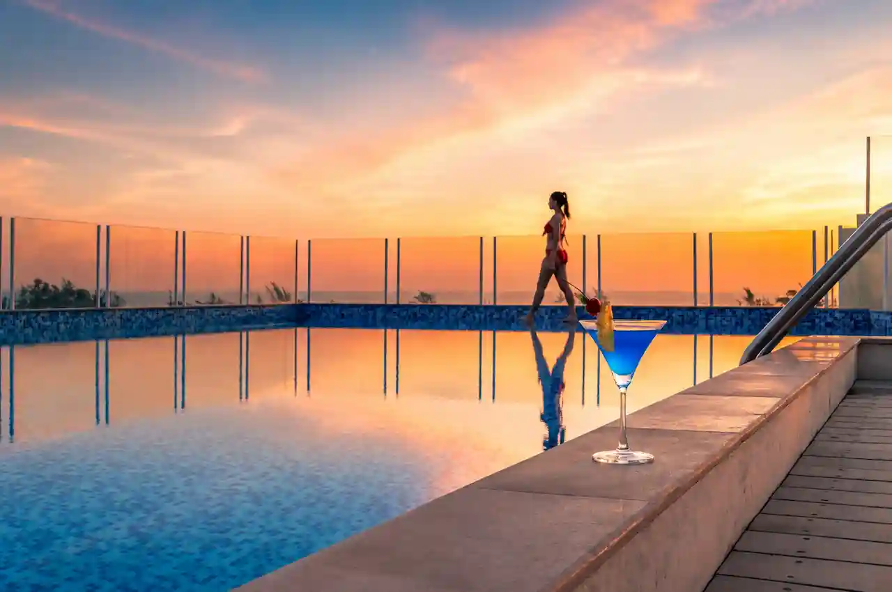 Modern Phuket resort pool area illuminated in the evening with a tropical sunset atmosphere