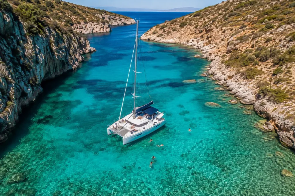 Catamaran and swimmers in a clear turquoise cove during an Antalya boat tour.