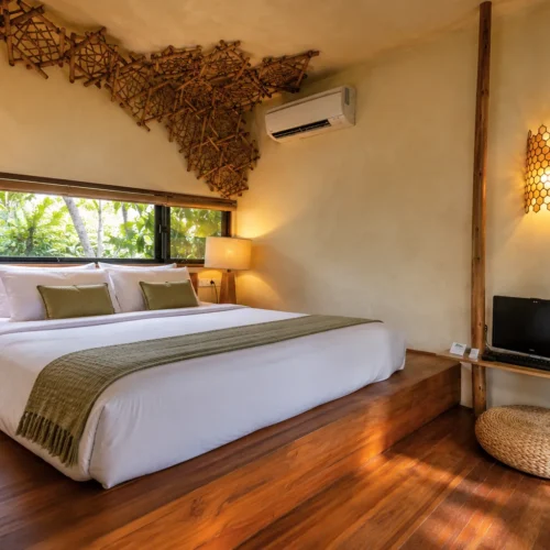 Natural eco treehouse bedroom with wooden floors, white bedding and tropical views