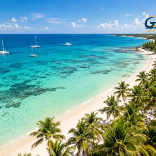 Aerial view of a Caribbean tropical coastline with turquoise waters, white-sand beaches, palm trees and luxury yachts.