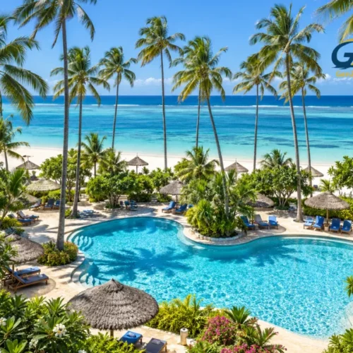 Zanzibar all-inclusive holiday resort featuring a tropical swimming pool, tall palm trees, sun loungers and turquoise Indian Ocean views.