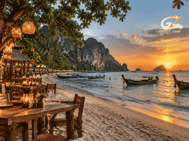 Thailand Christmas holiday package featuring a sunset beach, traditional longtail boats, festive lights and a beachfront restaurant.