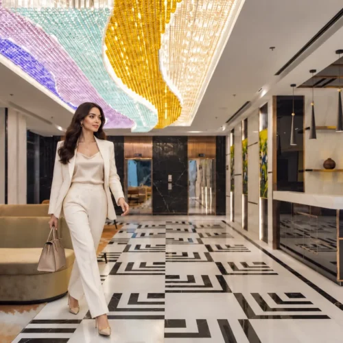 Female traveller walking through a modern luxury hotel lobby with elegant lighting and marble flooring in Hanoi, Vietnam.