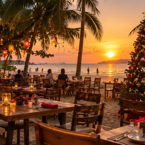 Christmas beach dinner in Thailand with a decorated Christmas tree, candlelit tables, palm trees and a beautiful sunset.